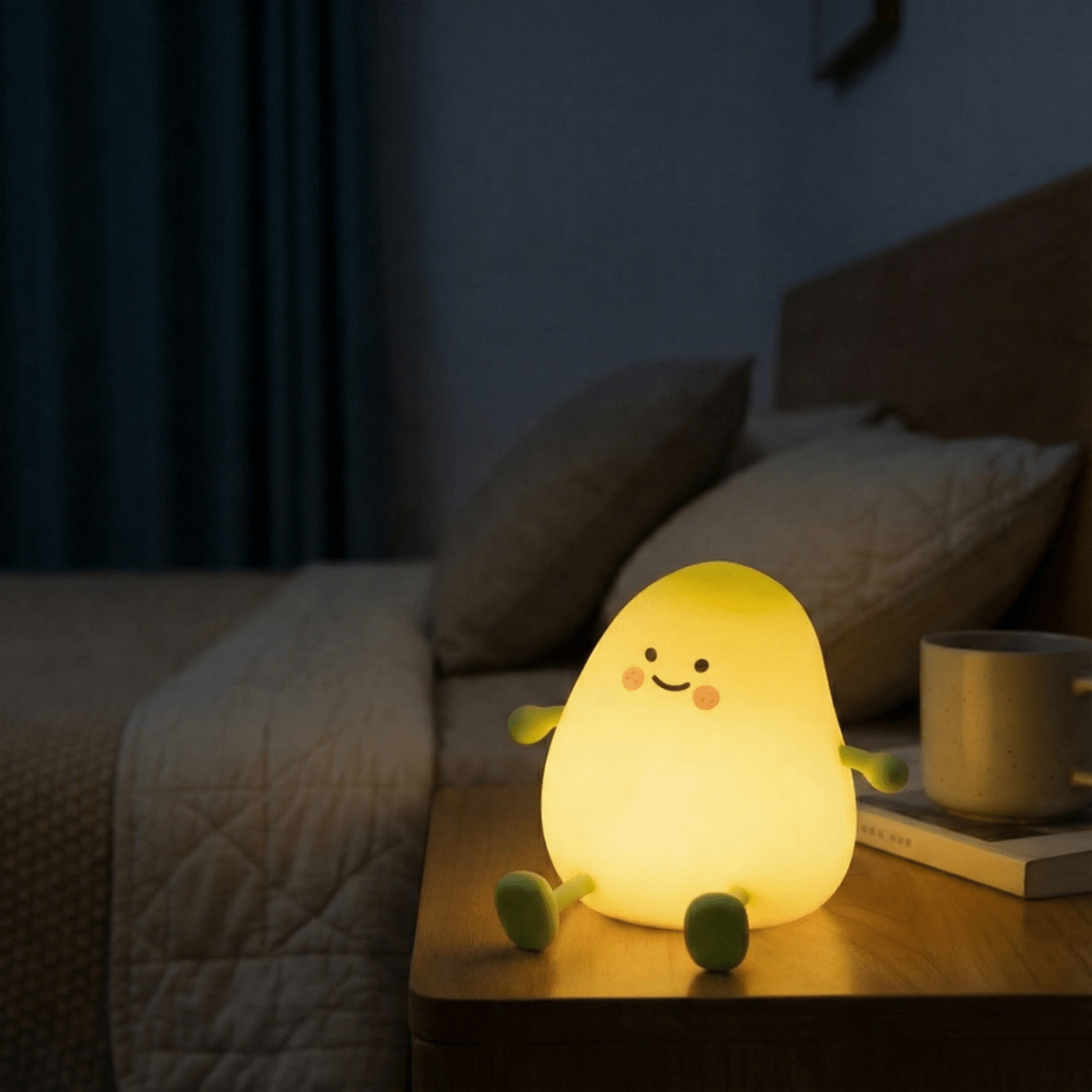 A cute, glowing yellow mango silicone night light sitting on a wooden bedside table in a cozy, dimly lit bedroom, providing a warm and soothing atmosphere for sleep.
