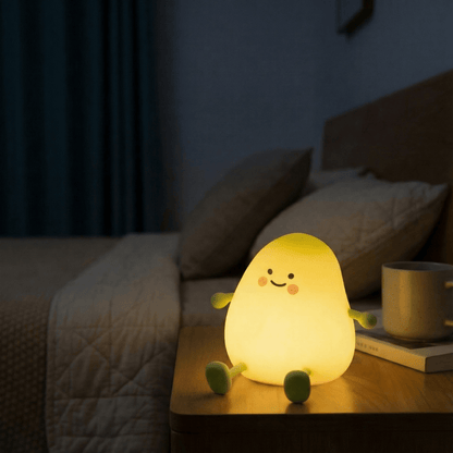 A cute, glowing yellow mango silicone night light sitting on a wooden bedside table in a cozy, dimly lit bedroom, providing a warm and soothing atmosphere for sleep.