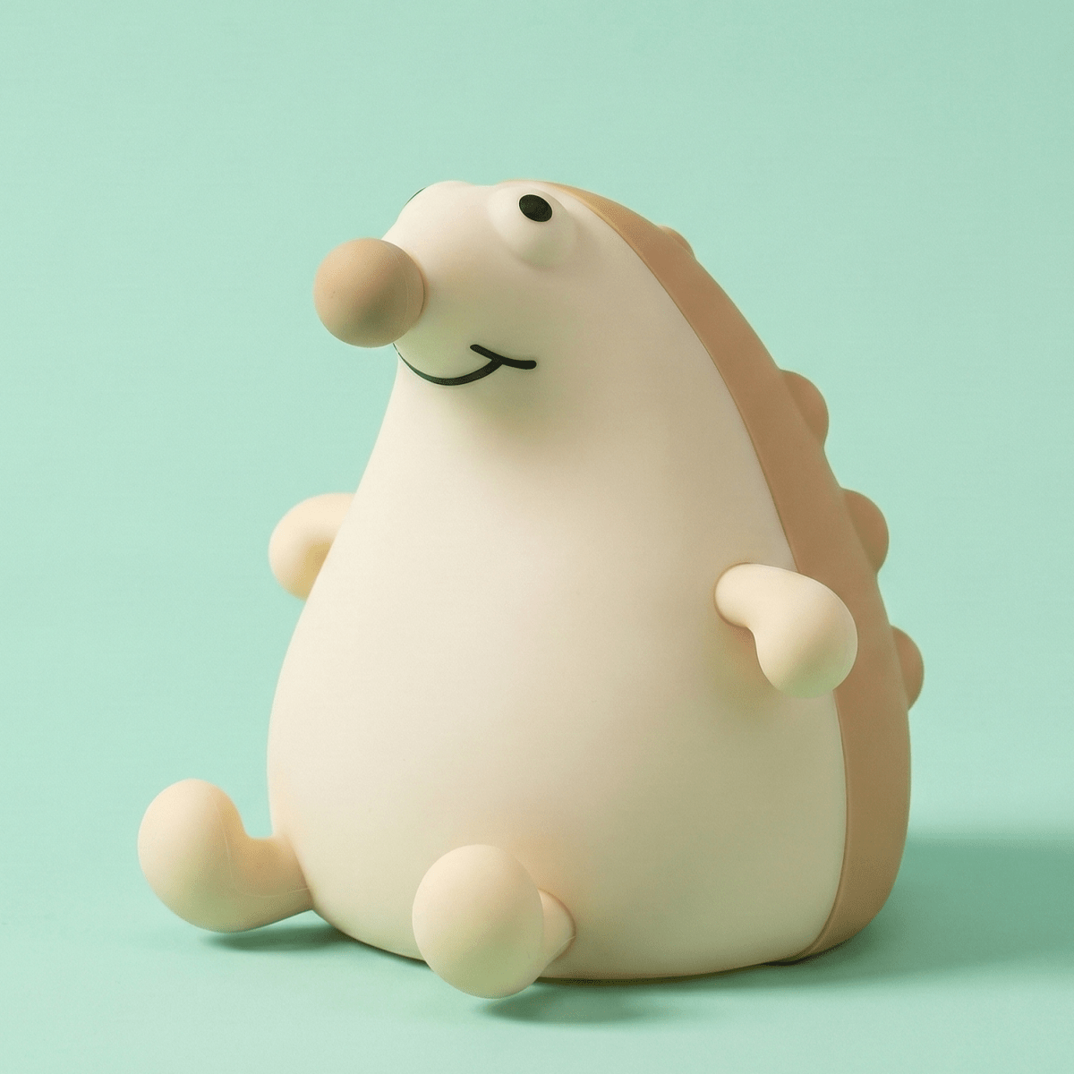 Cute smiling squishy hedgehog silicone night light with brown spikes sitting on a solid light green background.