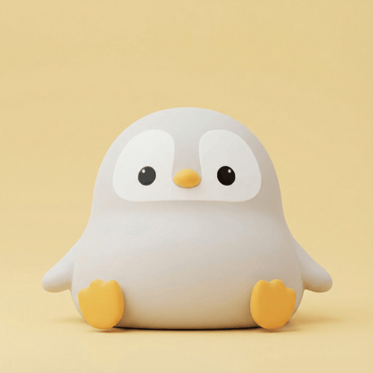 Cute light green squishy penguin silicone night light with a happy face and small limbs sitting on a solid pink background.